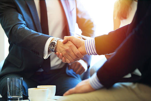 ビジネスの人々は握手をし、会議を終える。 - business relationship handshake business meeting ストックフォトと画像