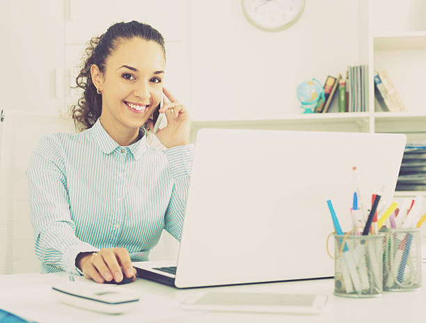 istock young woman talking by mobile in office 637367890