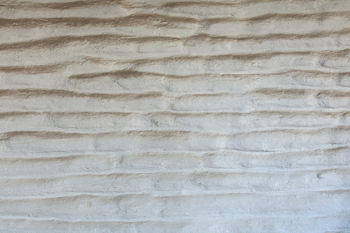 White and worn wall texture made of adobe bricks laid horizontally