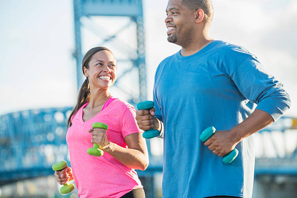 istock Black couple exercising together with handweights 637371218