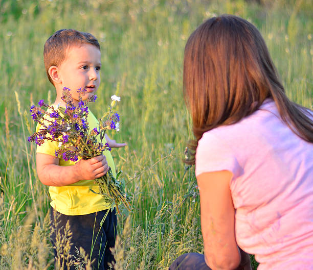 istock Boy giving mom flowers 637374112