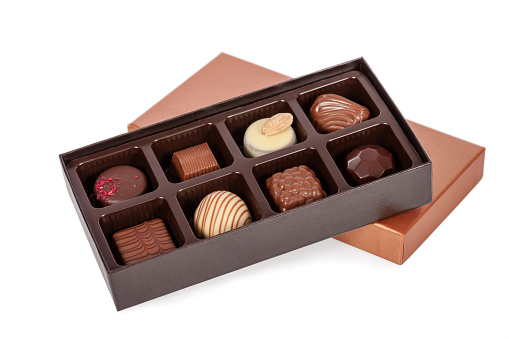 Box of gourmet bonbons, aka bon-bons and truffles made of dark, white and milk chocolate isolated on white background