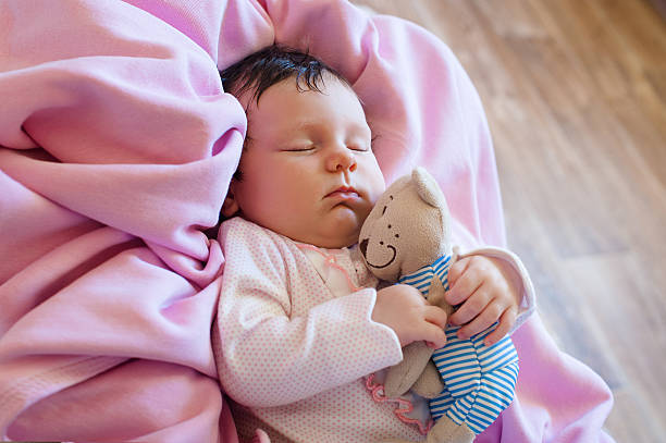 istock Cute newborn baby sleeps with a toy teddy bear 637380694
