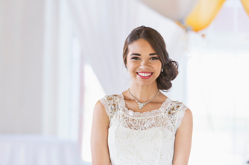 Portrait of a mixed race teenage girl wearing a white dress. She is ready for a special occasion, perhaps her prom or birthday party.
