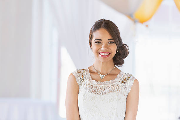 Young mixed race woman in white dress Portrait of a mixed race teenage girl wearing a white dress. She is ready for a special occasion, perhaps her prom or birthday party. prom fashion stock pictures, royalty-free photos & images