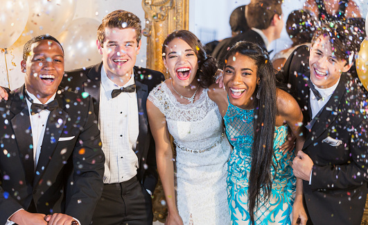 Adolescentes y adultos jóvenes en ropa formal en la fiesta photo