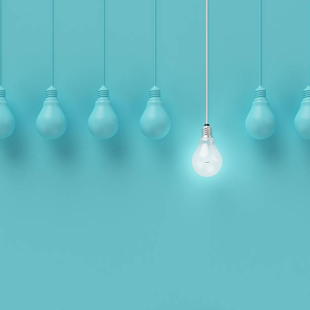 Hanging light bulbs with glowing one different idea. Hanging light bulbs with glowing one different idea on light blue background , Minimal concept idea , flat lay , top innovation individuality standing out from the crowd contrasts stock pictures, royalty-free photos & images