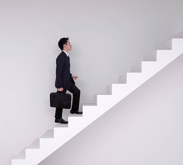 istock Business man stepping up on stairs 637385948