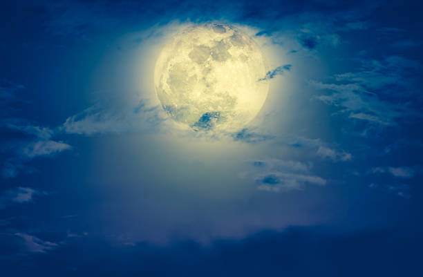 istock Nighttime sky with clouds and bright full moon. Cross process. 637386198