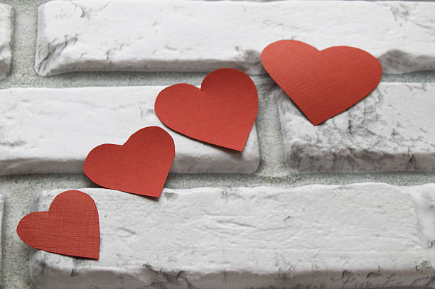 istock Four red heart Valentine's Day, white brick wall background 637387202