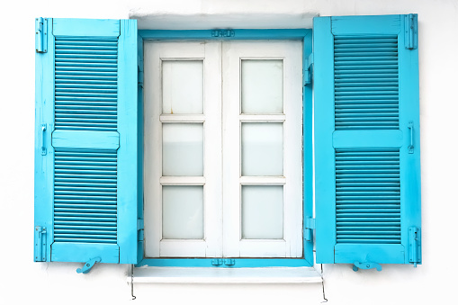 Vintage window with blue shutter on white wall