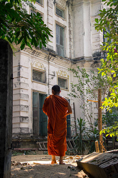 istock Buddhist monk is walking in front of an old building 637392466