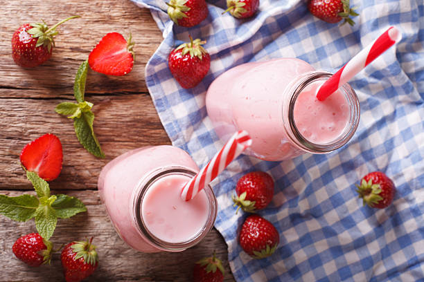 istock Cold strawberries milkshake in glass bottles close-up on the table 637396024
