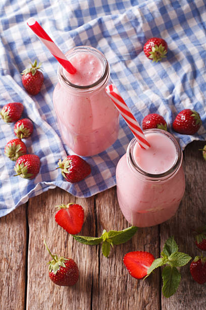 istock Cold strawberries milkshake in glass bottles close-up on the table 637397868