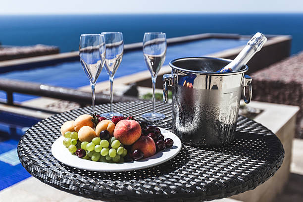 frutta fresca e secchio di champagne freddo a bordo piscina - beach table peach fruit foto e immagini stock