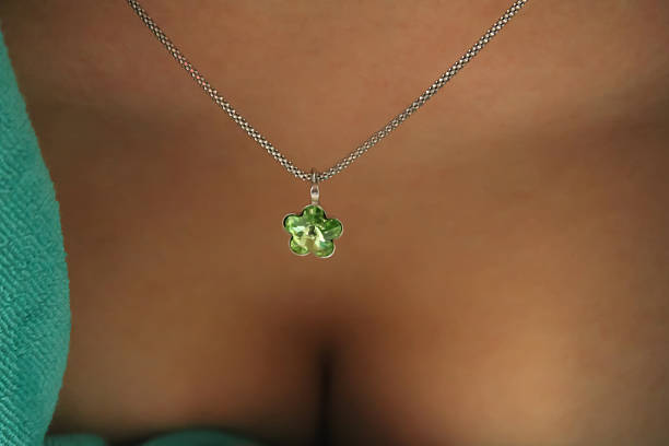 istock Beutiful silver necklace with green malachite gem.  Women breast background 637400882