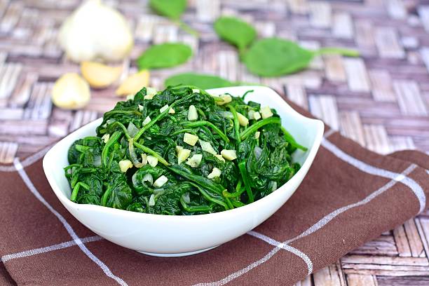 healthy sautéed spinach with minced garlic - espinafres imagens e fotografias de stock
