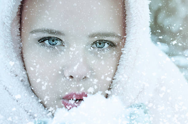 istock Little girl blows snow with mittens 637402052