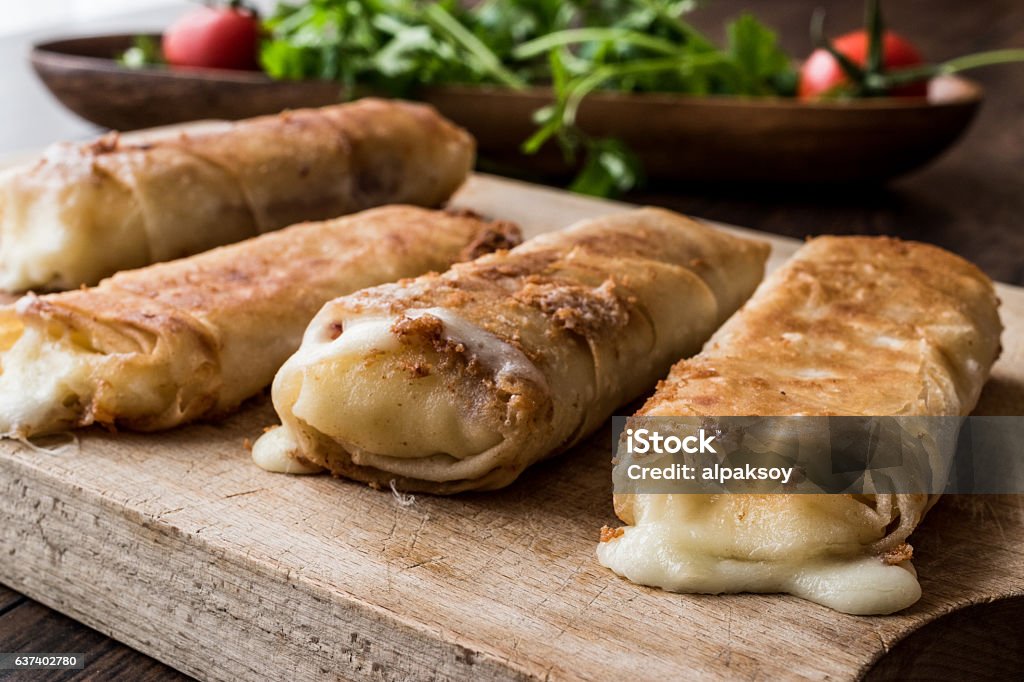 Turkish Pacanga Boregi with pastirma and cheddar (melted) cheese Turkish Pacanga Boregi with pastirma and cheddar (melted) cheese. / Pastirmali Borek on wooden surface Cheese Stock Photo