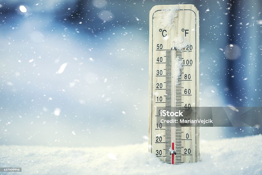 Thermometer on snow shows low temperatures under zero. Thermometer on snow shows low temperatures under zero. Low temperatures in degrees Celsius and fahrenheit. Cold winter weather twenty under zero.Thermometer on snow shows low temperatures under zero. Low temperatures in degrees Celsius and fahrenheit. Cold winter weather twenty under zero. Cold Temperature Stock Photo