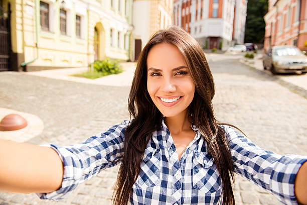 istock Beautiful young runette with beaming smile making selfie 637410056