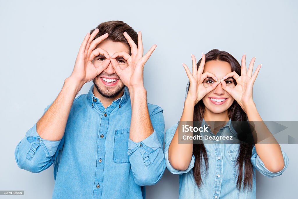 Porträt von zwei glücklichen lustigen Liebhaberhalten Finger in der Nähe von Augen - Lizenzfrei Brille Stock-Foto