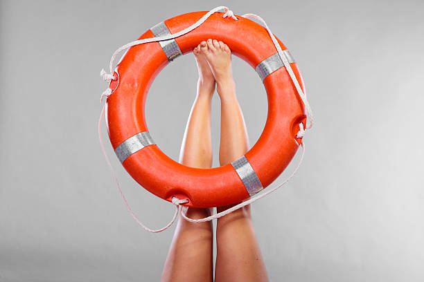 istock Life buoy ring on female legs 637413336