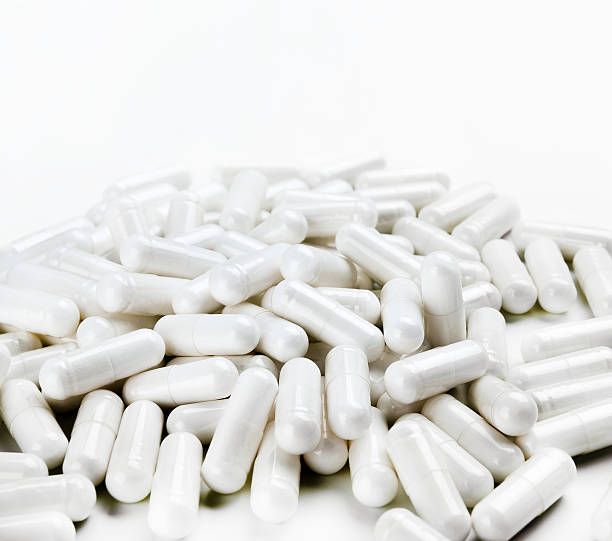 istock Pile of white capsules on white background. 637416656