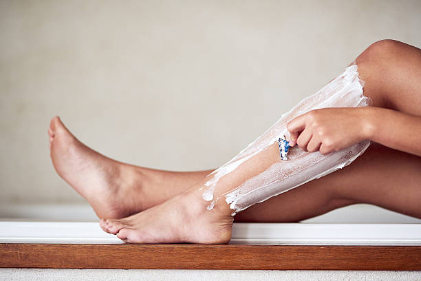 滑らかな、無毛の足は彼女の欲望です - shaving human leg female shaving cream ストックフォトと画像