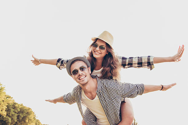 Happy young man piggybacking his girlfriend.