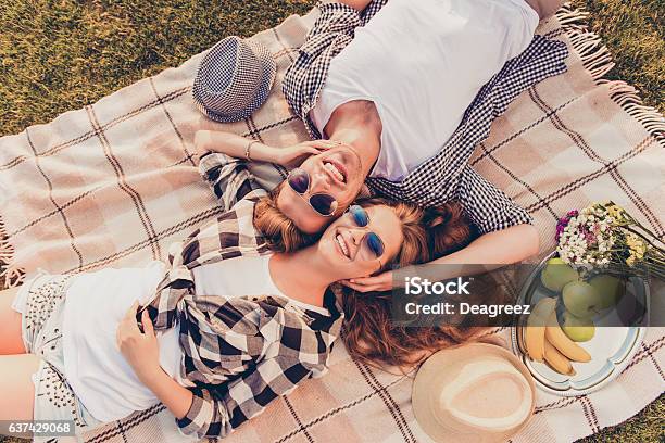 Topview Of A Couple In Love Lying On Picnic Plaid Stock Photo - Download Image Now - Summer, Yard - Grounds, Couple - Relationship