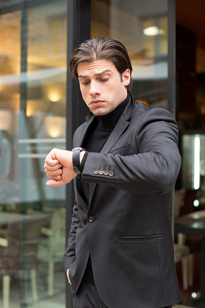 istock Handsome young man looking at his watch 637443444