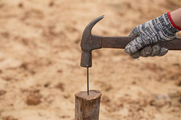 istock Worker hammering nail into wood 637443772
