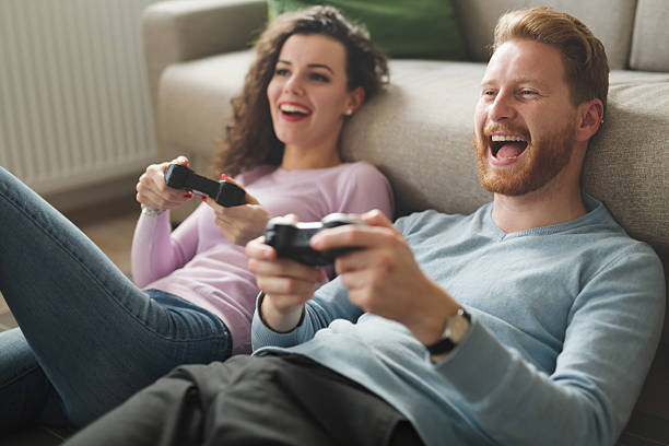 hermosa pareja jugando videojuegos en la consola - couple young women casual excitement fotografías e imágenes de stock