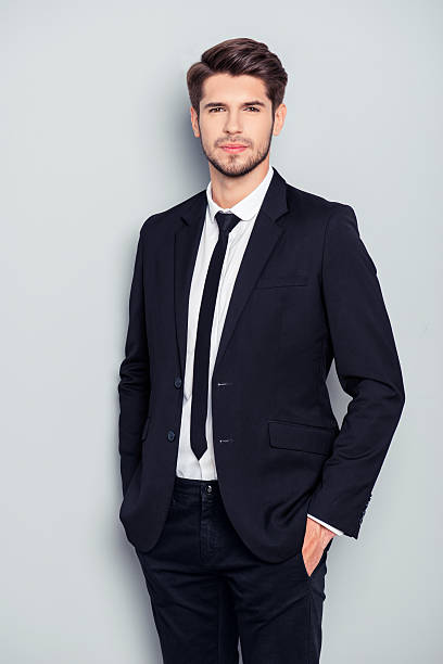 istock Handsome bearded man in suit holding hands in pockets 637468522