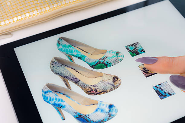 istock Woman with Tablet selecting snakeskin peeptoe pumps online 637468954