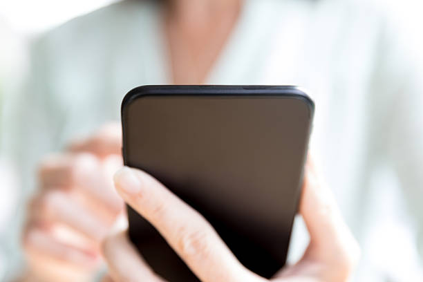 istock Woman Holding Using Black Smart Phone in Coffee Shop 637481116
