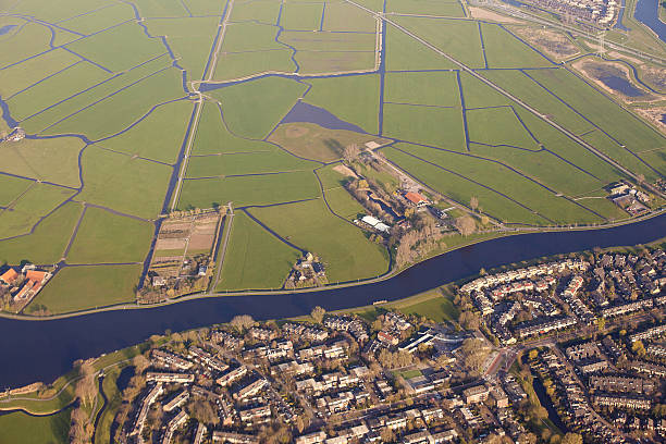 Dutch landscape with village, green fields and canal