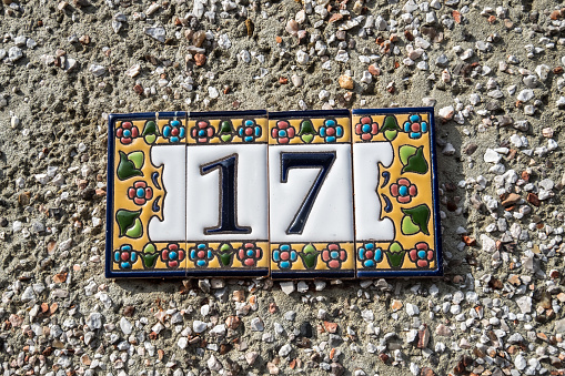a decorated street number sign with the number 17