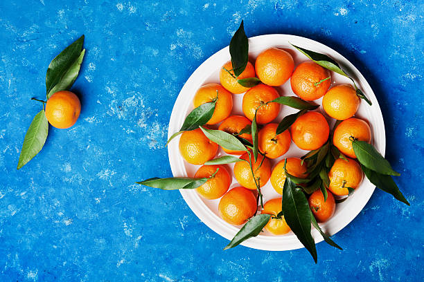 istock Tangerines or mandarins on vintage blue table. Flat lay style. 637504652