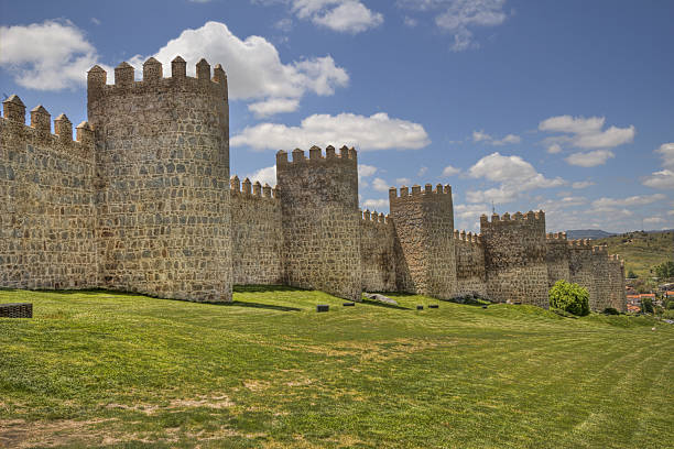 Ancient city walls of Avila, Spain Ancient city walls and grass lawn in the old city of Avila, Spain fort stock pictures, royalty-free photos & images
