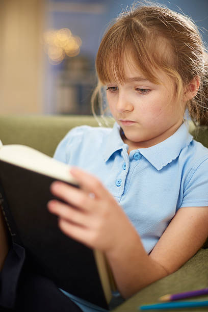 istock schoolgirl reading at home 637505478