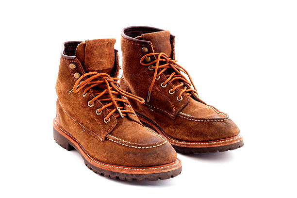 istock Pair of old yellow working boots Isolated on white background 637506438