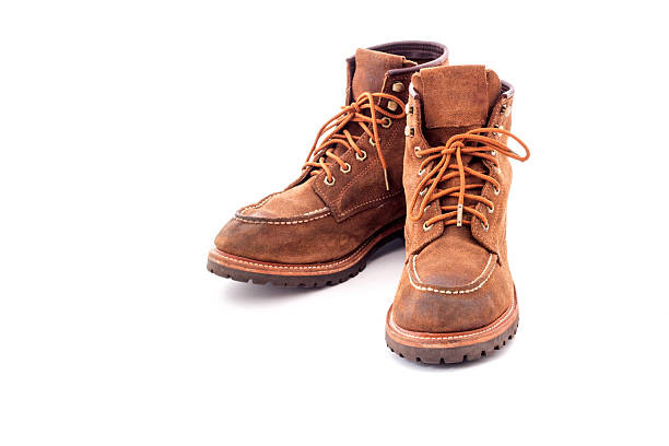 istock Pair of old yellow working boots Isolated on white background 637506478