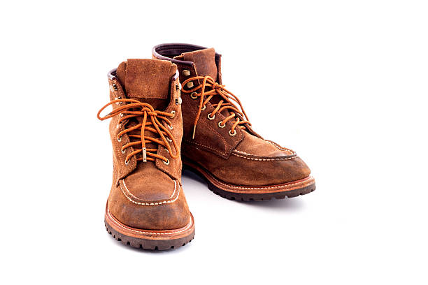 istock Pair of old yellow working boots Isolated on white background 637506524