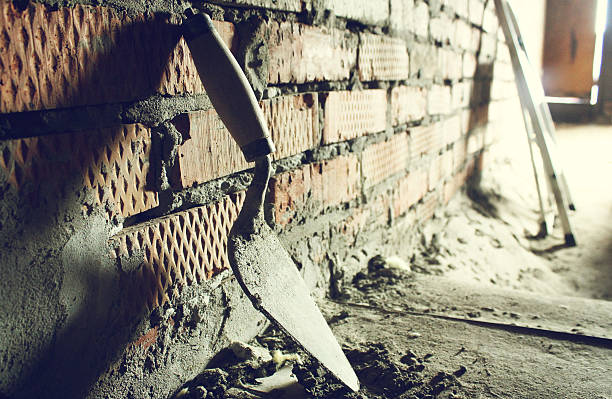 Trowel on a brick wall background stock photo