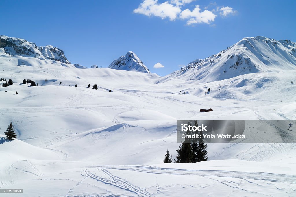 Ski snowy slopes through alpine mountains and valleys Ski pistes crossing alpine valley and rugged mountains, Paradiski, Plagne, Alps, France La Plagne Stock Photo