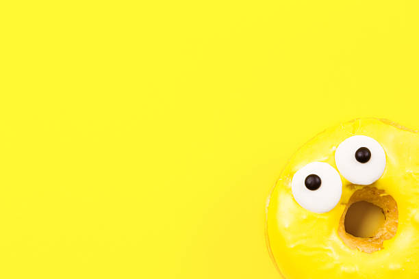 istock Round donut with eyes on yellow background. Flat lay, top 637511190