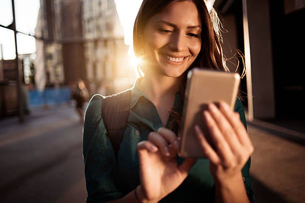 スマートフォンを使用して若い幸せな女性 - シドニー 写真 ストックフォトと画像