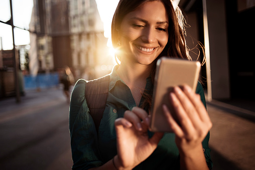 Young happy woman using smartphone